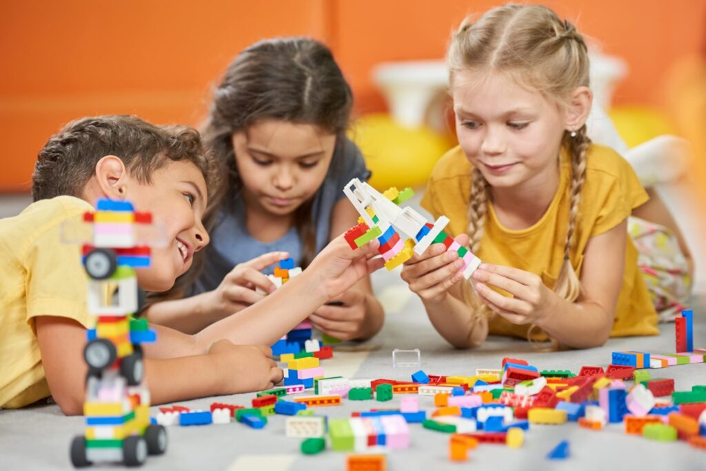 deux filles et un garçon qui s'amusent à jouer au jeu de construction